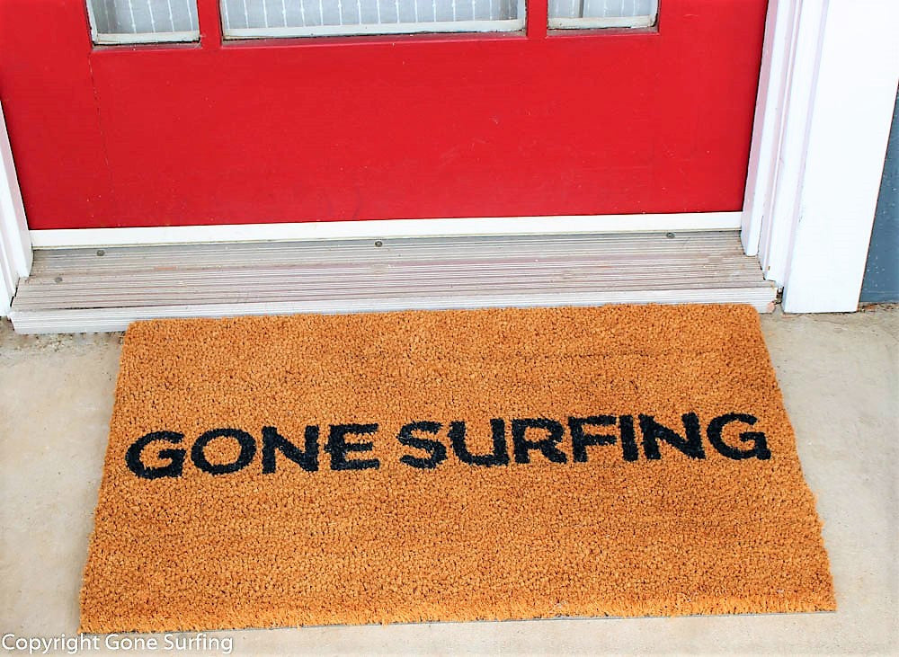 Gone Surfing Company Trademarked Doormat Navy Blue Dye with Gone Surfing in capitals across mat with sturdy vinyl backing in front of a door